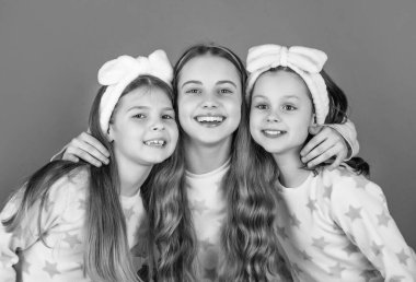 Ev elbisesi pembe arka planda gülümseyen çocukların portresi..