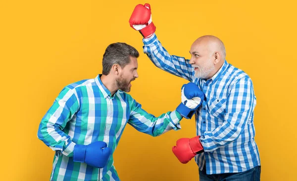 aggressive two generation men has disagreement isolated on yellow. generation men with disagreement in studio. generation men having disagreement on background. photo of generation men disagreement.