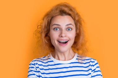 Şaşırmış kızıl saçlı kadın yüzü sarı arka planda izole edilmiş. Stüdyodaki genç kızıl saçlı kadının yüzü. Yetişkin kızıl saçlı kadın yüzü.