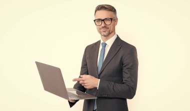 cheerful mature businessman working on laptop isolated on white background.