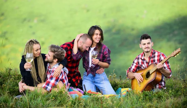 Group friends relaxing picnic. Friends enjoy vacation. Hike picnic. People eating food. Youth having fun picnic in highlands. Summer adventures. Hike with guitar. Leisure in nature. Celebrate holiday.