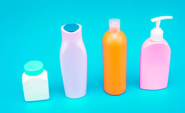 Great for packaging. Bottles for beauty products. Plastic bottles and jar blue background. HDPE. Cosmetic packing. Liquid containers. For toiletry, copy space.
