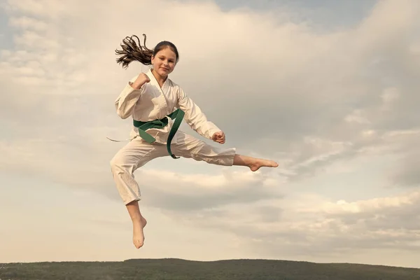 judo concept. teen girl practicing judo. girl judo fighter on sky background.