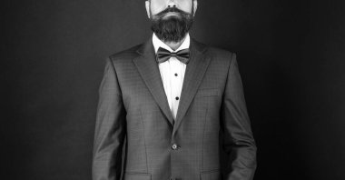 Smokinli papyonlu kırpık adam. Siyah arka planda resmi giyinmiş bir gelin. erkek resmi moda.