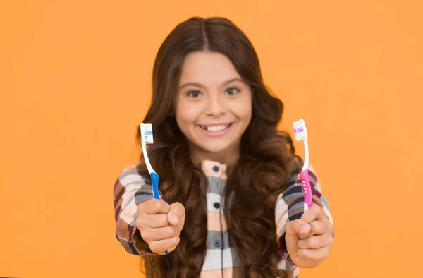 First rule of personal hygiene. Tooth brushes for dental hygiene. Toothbrushes in kids hands selecitive focus. Proper oral hygiene requires regular brushing. For fresh breath practice good hygiene.