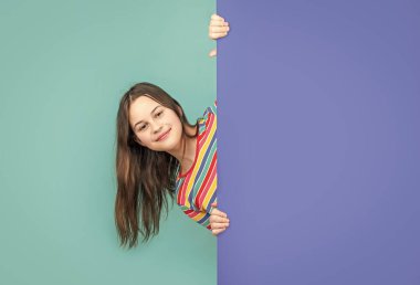 Boş mavi kağıdın arkasında reklam için fotokopi alanı olan mutlu bir çocuk..