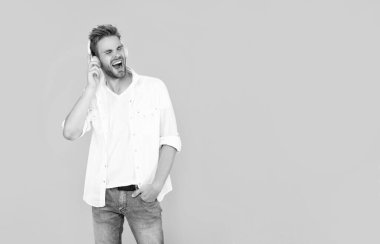 Online eğitim. Okula dönüyorum. Kulaklıklı genç adam. Müzik dinle. Kablosuz cihaz aksesuarı. Yeni teknoloji. Modern kulaklıklı bağıran adam..