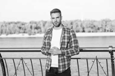 Dama gömlekli, modaya uygun yakışıklı bir adam. Dışarıdaki traşsız genç adam. Erkek manken. Erkeklerin güzelliği.