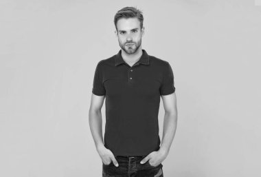 Sarı arka planda sakallı genç bir adam. Saç ve sakal bakımı. Kendine güvenen ve yakışıklı, tıraşsız adam. Erkek modası. Erkek güzelliği. Kırmızı gömlekli kıllı adam..