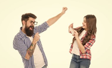 Just for fun. Daughter taking photo of cheerful father. Happy little girl hold smartphone or mobile phone white background. Future photographer. Application for editing photo. Mobile photography.