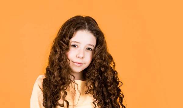 Long hair. Easy hairdo. Beauty supplies. Perfectly untangle curly hair. Pretty girl curly hair yellow background. Hairdresser salon. Adorable small child. Beautiful little model. Healthy curls.