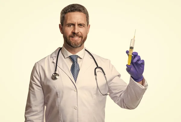 Happy doctor holding medical syringe. Surgeon prepared injection syringe. Plastic syringe for injecting liquids.
