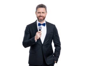 man presenter wear tuxedo in studio with copy space. presenter man speaking in microphone. man presenter isolated on white background. presenter man with microphone.