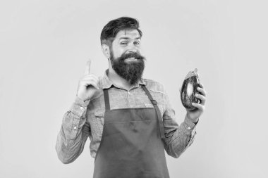 Önlüklü mutlu bir adam parmağını sarı arka planda tutmayı bilir, dükkan sahibi..