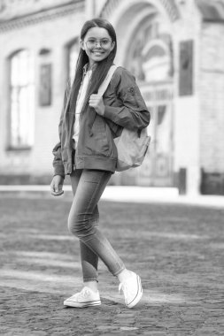 Sırt çantalı, gülümseyen bir çocuk gözlüğü takıyor. Okula geri dön..