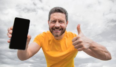 Mutlu adam akıllı telefon ekranını kopyalama alanı ile sunuyor.