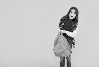 Sırt çantası sarı arka planda fotokopi alanı ve kolej olan mutsuz çocuk gündelik tarzı.