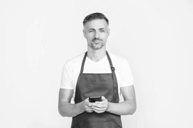 Önlüklü olgun bir adam telefonda konuşuyor..