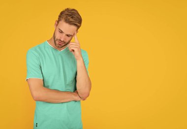 Kırmızı gömlekli, sarı arkaplanlı, fotokopi alanı olan sıradan bir adam..