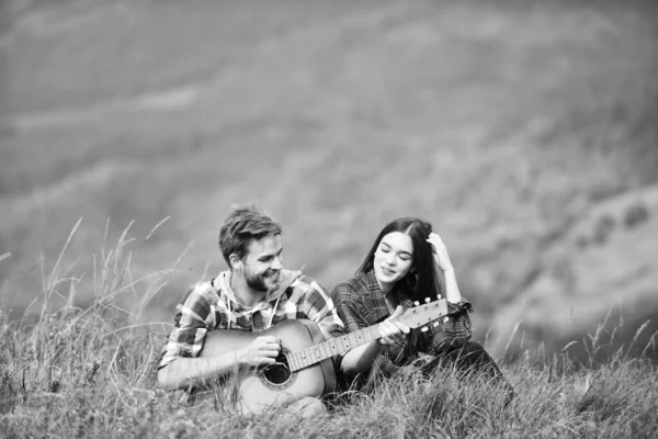 true love. men play guitar for girl. couple in love spend free time together. western camping. hiking adventure. happy friends with guitar. friendship. campfire songs. country music. romantic date.