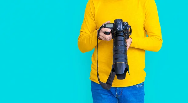 cropped view of man photographer with camera in studio. man photographer with camera on background. photo of man photographer with camera. man photographer with camera isolated on blue.