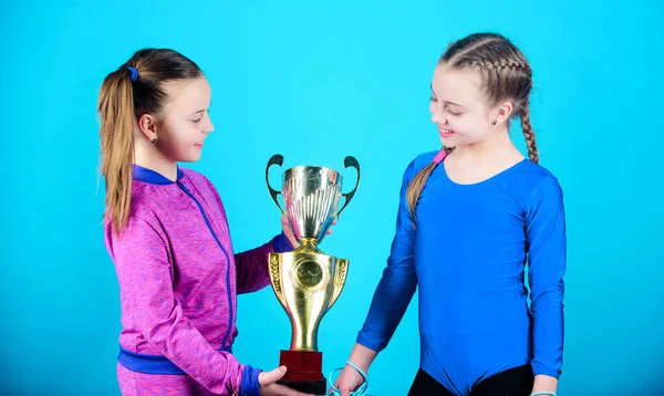 Winners in competition. victory of teen girls. Sport success. Acrobatics and gymnastics. Little girls hold jump rope. Happy children with gold champion cup. in the big league. league champions.