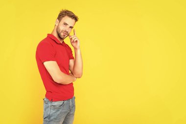 Erkek güzelliği. Kırmızı gömlekli kıllı adam. Sarı arka planda sakallı düşünceli genç bir adam. Saç ve sakal bakımı. Kendine güvenen ve yakışıklı, tıraşsız adam. Erkek modası.