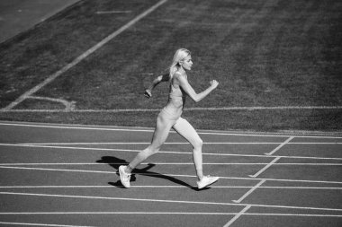 Büyük ilerleme. Hareket halindeki kadın spor eğitmeni. Hız ve enerji. Dayanıklılık. Spor giyim sektöründe seksi bir koşucu. Açık hava arena pistinde koşuyor. Antrenman ve antrenman. Koşu yapan atletik bayan koç.