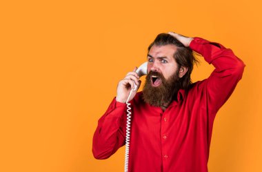Beklenmedik arama. Telefon görüşmesi. Sakallı adam. Modern hayatta iletişim. Telefonda arkadaşınla konuş. Olgun erkek retro telefonu tutar. Bıyıklı adam çağrıya cevap veriyor. Boşluğu kopyala.