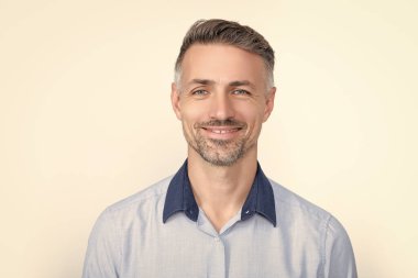 Gri arka planda ofis gömleği içinde mutlu bir iş adamı..