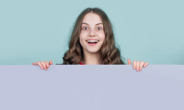 Erstauntes Kind Hinter Blauem Papier Mit Kopierplatz Für Werbung — Stockfoto