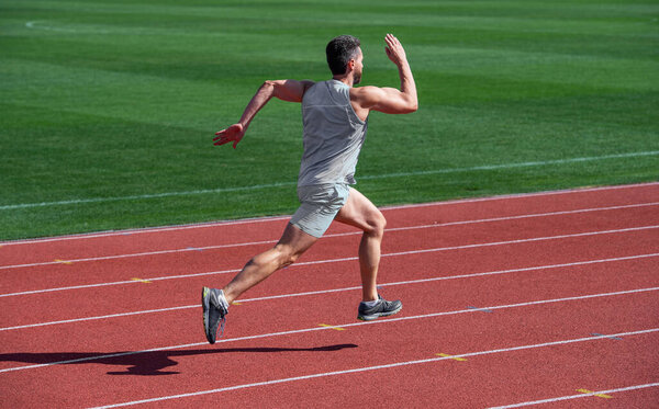 athlete runner do aerobic or anaerobic load. man start running on stadium. fitness gym outdoor. muscular athletic runner training. sport. male endurance and stamina. successful sportsman finishing.