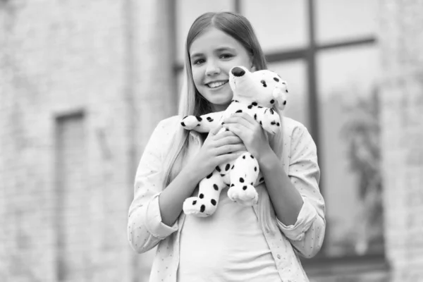 幸せな女の子子供でカジュアル抱きしめふわふわおもちゃ屋外 子供時代 — ストック写真