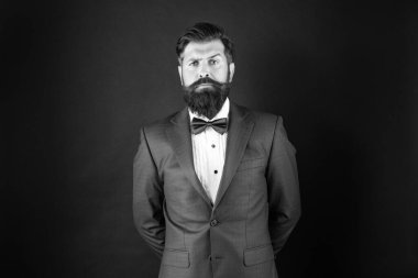 serious man in tuxedo bow tie. gentleman in formalwear on black background. male formal fashion.