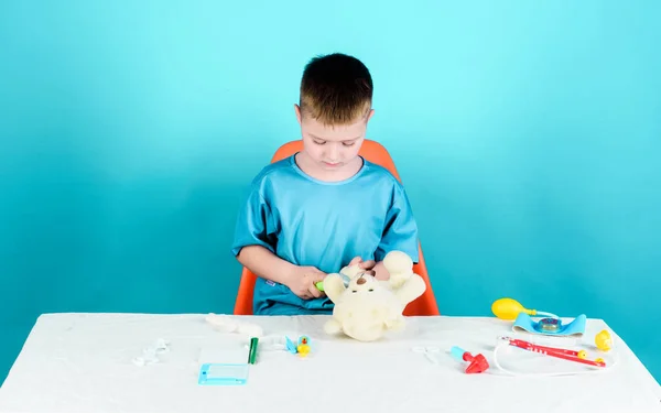 귀여운 아이가 미래의 의사가 의사는 도구들을 가지고 테이블에 있느라 바쁩니다 — 스톡 사진