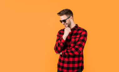 Yakışıklı, kendine güvenen, gözlüklü genç bir adam. Mutlu adam gülümsüyor. Gömlekli yakışıklı bir adamın portresi. Kareli baskılı klasik erkek gömlekleri. Boşluğu kopyala.