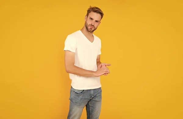 hair and beard care. confident and handsome unshaven guy. male casual fashion. mens beauty. man with bristle in white shirt. young man with beard on yellow background.