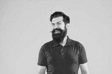 Sarı arka planda sakallı ve saç stili olan gülümseyen adam, portre..