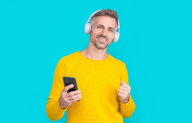 Stüdyoda mp3 çalma listesi olmasına sevindim. Arka planda mp3 açık çalma listesi var. mp3 'te açık çalma listesi olan bir adamın fotoğrafı. MP3 üzerindeki adam açık çalma listesi mavi üzerine izole edildi.