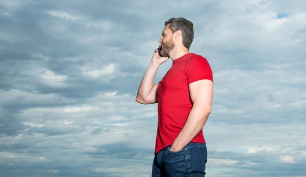 Adam Telefonda Konuşuyor Kırmızı Tişört Giyiyor Pankart Takıyor Adamın Fotoğrafı — Stok fotoğraf