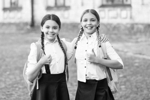 快乐的孩子们穿着校服 背着背包在一起 大拇指向上 — 图库照片