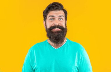 Arka planda neşeli sakallı adam. Bıyıklı sakallı adamın fotoğrafı. Sakallı adam sarıda izole edilmiş. Stüdyodaki sakallı adam.