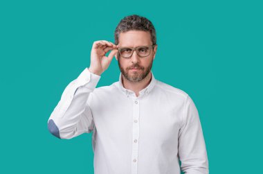 Mavi arka planda izole edilmiş bir adamın görüşü. Stüdyoda görme yeteneği olan olgun bir adam. Gözlük takan bir adam. Görme sorunu olan olgun bir adamın fotoğrafı..