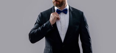 Resmi smokinli adam gri arka planda izole edilmiş. Stüdyoda resmi smokin giyen adam. Resmi smokin giyen bir adamın fotoğrafı. Erkekler resmi smokin giyer..