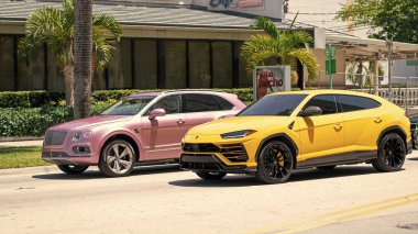 Miami Beach, Florida ABD - 15 Nisan 2021 Bentley Bentayga v8 2015 ve Giallo Auge Lamborghini Urus.