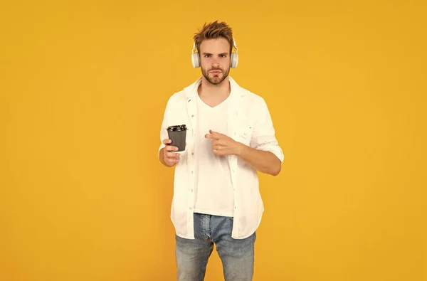 音乐爱好者 听音乐 无线设备配件 新技术 戴耳机的男人把手指放在咖啡杯上 网上教育 回学校去戴耳机的年轻人喝咖啡 — 图库照片