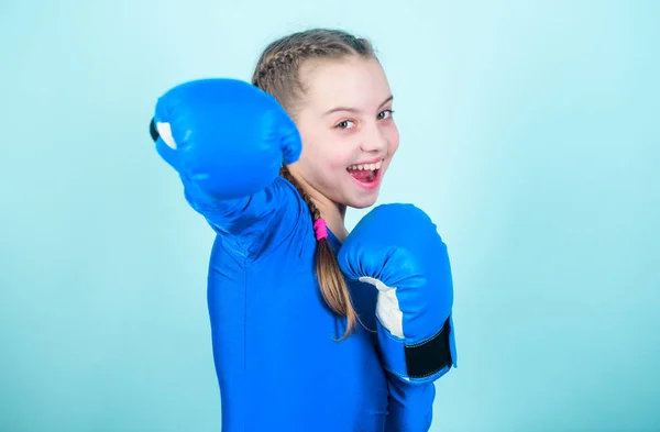 With great power comes great responsibility. Boxer child in boxing gloves. Girl cute boxer on blue background. Rise of women boxers. Female boxer change attitudes within sport. Feminism concept.