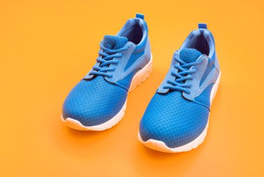 Sarı arka planda bir çift rahat mavi spor ayakkabı, ayakkabı..