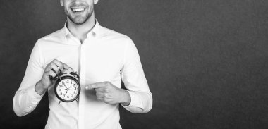 Mutlu profesyonel kırpma görünümü alarm saatini işaret ediyor. Koyu arkaplan kopyalama alanı, geri sayım alanı.