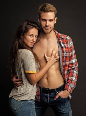 Birbirine aşık seksi genç çift, siyah arka planda, birliktelikte arzu hisseder..